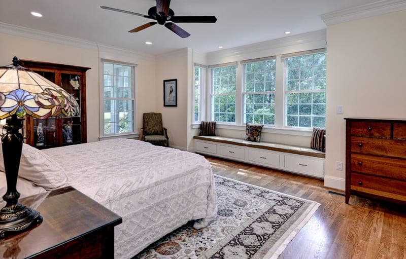 Primary bedroom with a custom window seat and hardwood floors